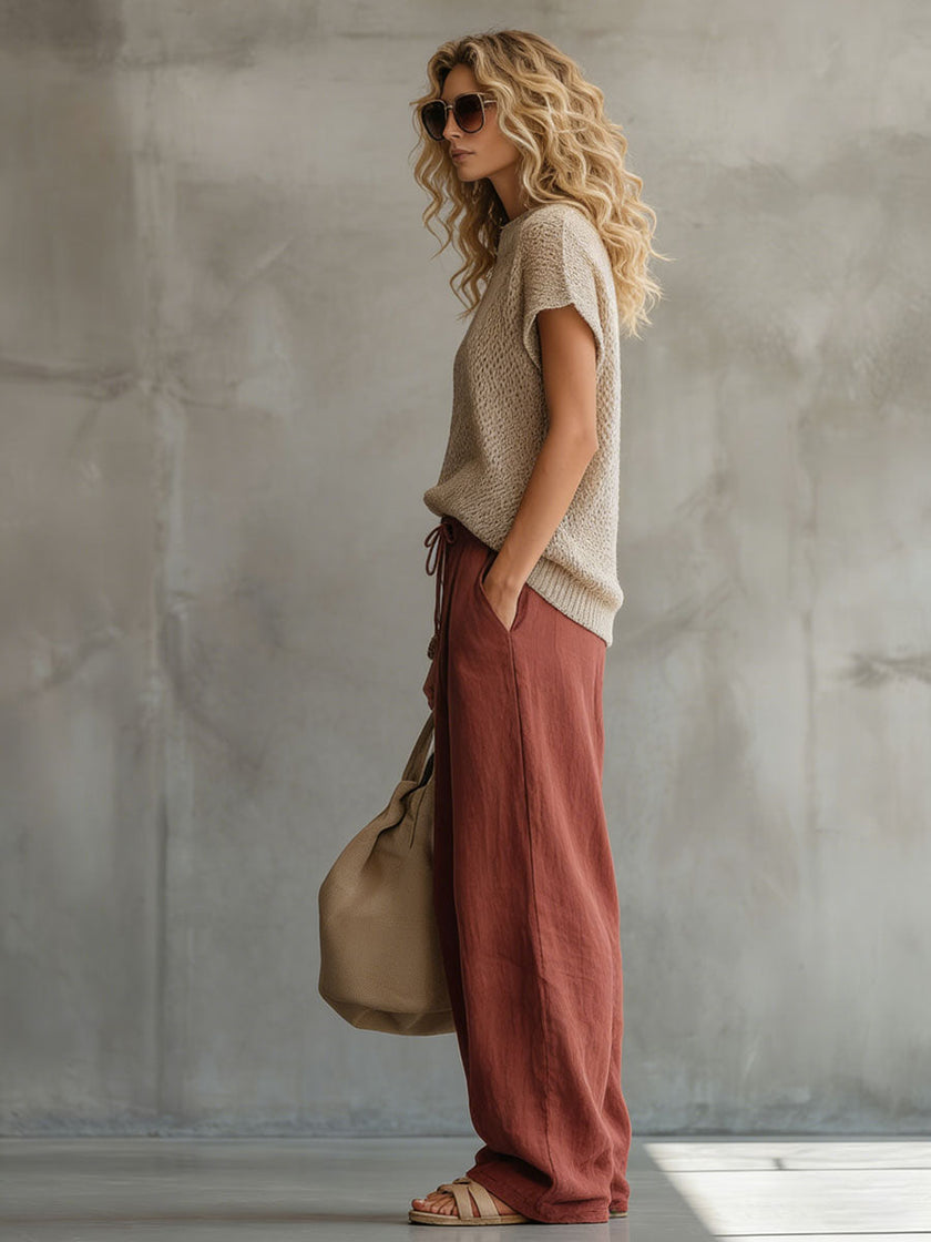 FJØRNA brick red cotton linen wide-leg women's trousers displayed on a model, showcasing relaxed fit and casual style.