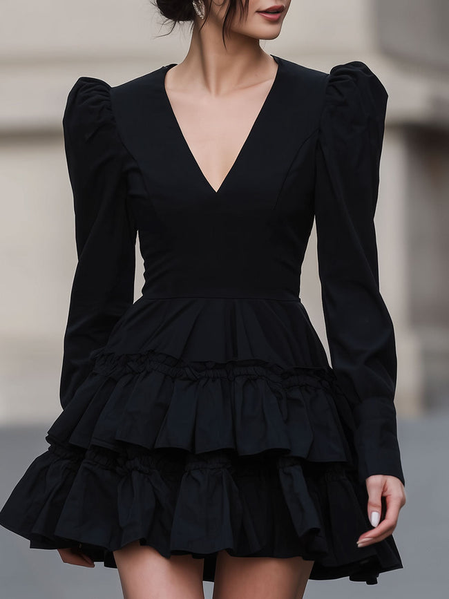 FJØRNA black leather mini dress with puff sleeves and tiered design, stylish and dramatic for evening wear or special occasions.