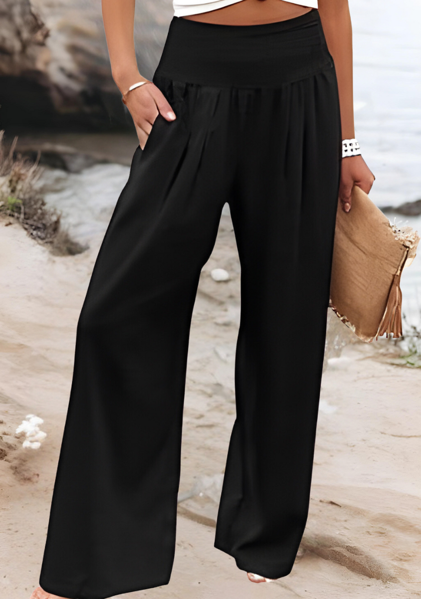 FJØRNA lightweight summer women's wide-leg trousers, relaxed fit beach clothing, shown in a natural beige color.