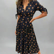 FJØRNA summer mini dress for women featuring a polka dot pattern and V-neck design, perfect for warm weather.