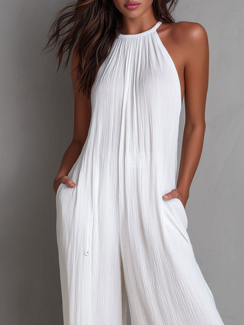 White pleated halter neck wide-leg resort jumpsuit for women by FJØRNA, featuring stylish pleats and a relaxed fit.