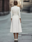 FJØRNA gold midi dress for women with V-neck, A-line silhouette, three-quarter sleeves, perfect for elegant occasions.