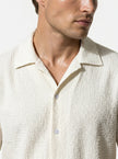 Close-up of FJØRNA men's casual summer short-sleeve button-up shirt, showing fabric texture and collar details.