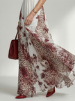 FJØRNA women's summer maxi dress with floral print, long sleeves, and pleated design, flowing fabric perfect for warm weather.