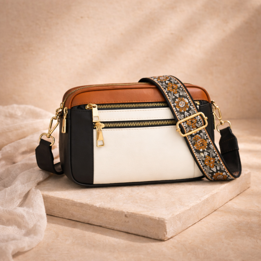 Black FJØRNA leather shoulder bag for women, featuring a sleek design with a top handle and adjustable shoulder strap.