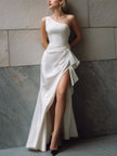 FJØRNA white one-shoulder satin gown with front slit, elegant black tie dress, featuring draped design and sleek silhouette.