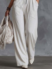 White faux suede Western fringe V-neck jumpsuit for women, featuring fringe details and a stylish V-neck design.