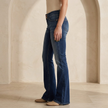Women's mid-waist slim-fit flared stretch jeans by FJØRNA, showing the dark denim fabric and flared leg style.