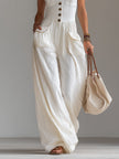 White sleeveless wide-leg jumpsuit with patch pockets for women, stylish FJØRNA pants featuring a relaxed fit.