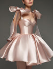 Light pink satin cocktail dress for women with sweetheart neckline, corset bodice, and bow detail by FJØRNA.