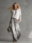 White leopard print chiffon wide-leg trousers for women by FJØRNA, featuring flowy fabric and relaxed fit.