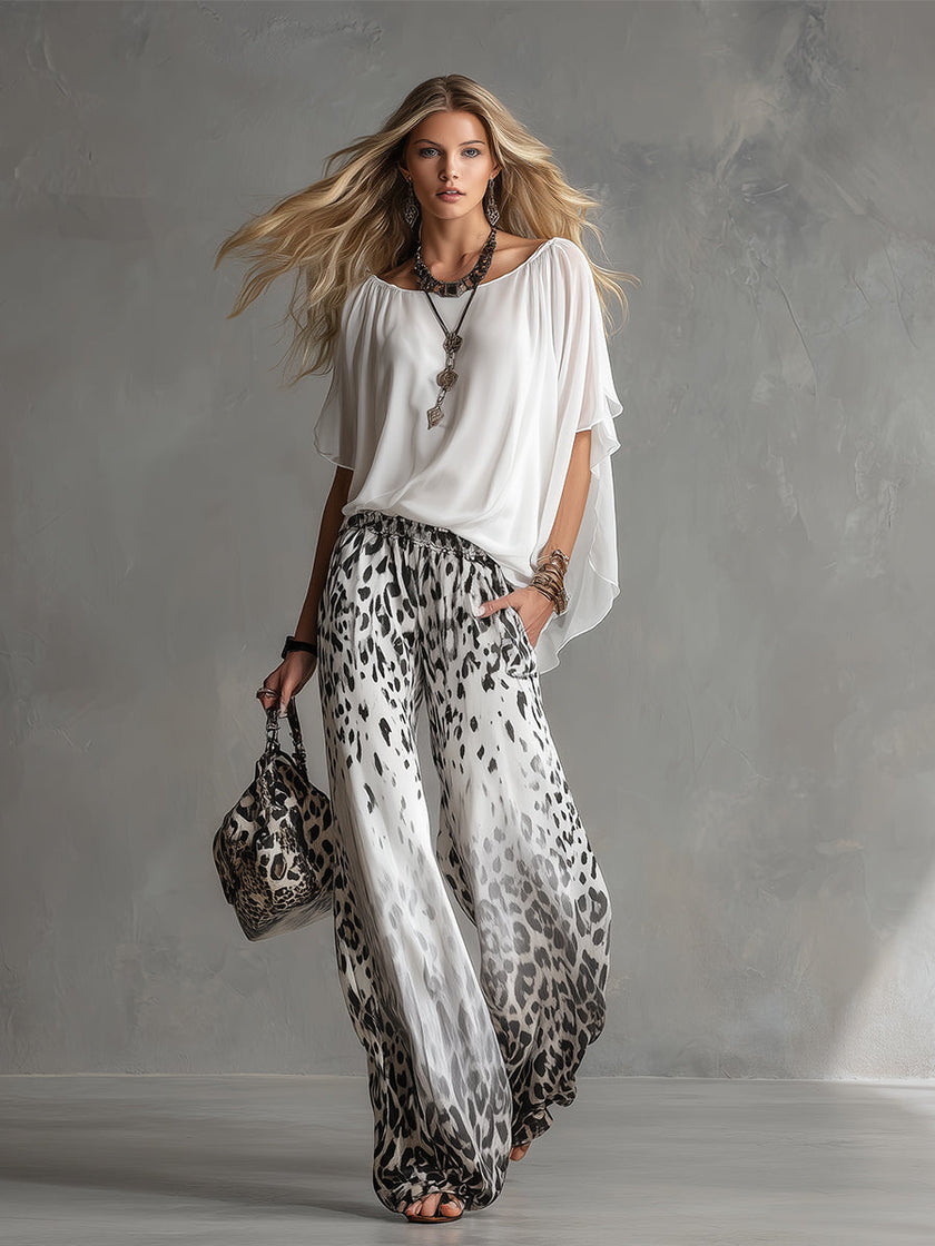 White leopard print chiffon wide-leg trousers for women by FJØRNA, featuring flowy fabric and relaxed fit.