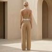 FJØRNA pinstripe strapless wide-leg jumpsuit for women, featuring a fitted bodice and flowing wide-leg pants, perfect for wedding guests.