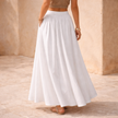 FJØRNA high-waist white A-line maxi skirt for women, flowing and elegant full-length skirt displayed on a model.