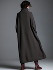 Brown knit maxi dress for women by FJØRNA, featuring a flowing design and long sleeves, perfect for casual and elegant occasions.