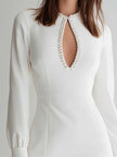 White long-sleeve pearl keyhole mini dress for women by FJØRNA, featuring a fitted silhouette and elegant neckline.
