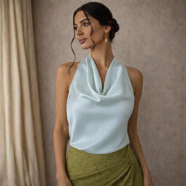 Cream satin cowl neck sleeveless top for women by FJØRNA, featuring a mock neck and smooth, shiny fabric.