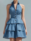 Blue FJØRNA halter-neck tiered ruffle denim mini dress with ruffled details and a fitted silhouette, perfect for casual summer wear.