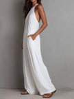 White pleated halter neck wide-leg women’s resort jumpsuit by FJØRNA, featuring flowing fabric and stylish design.