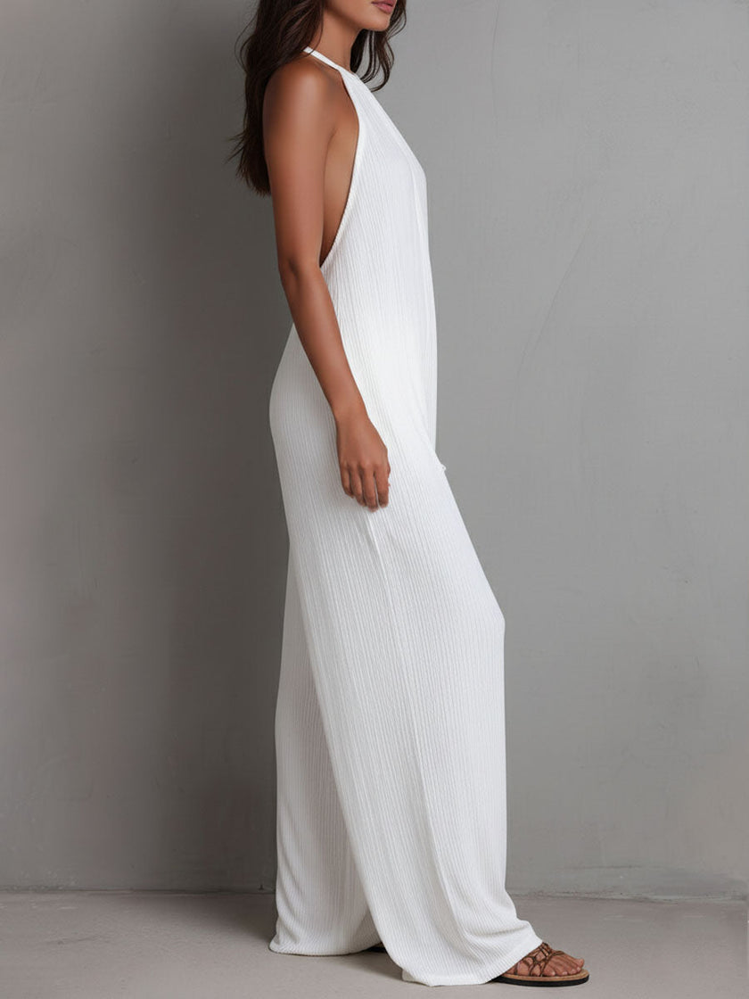 White pleated halter neck wide-leg resort jumpsuit for women by FJØRNA, featuring stylish pleats and a relaxed fit.