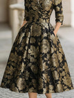 FJØRNA black and gold floral jacquard midi dress with a fitted silhouette and feminine tie detail at the waist.