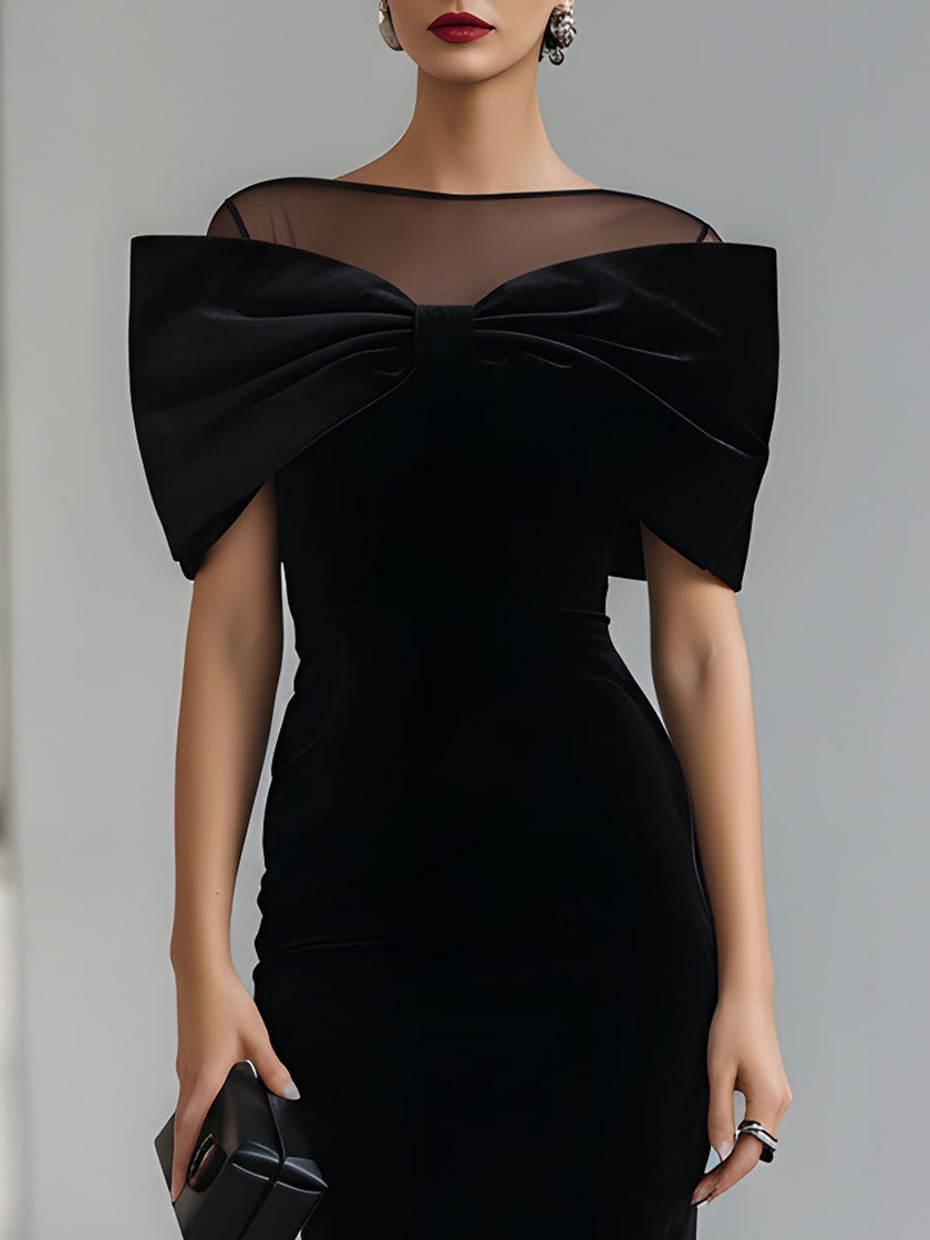 FJØRNA black velvet bow midi dress featuring a fitted silhouette, elegant neckline, and classic bow detail for formal occasions.