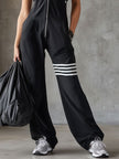 FJØRNA black sleeveless hooded jumpsuit with white vertical stripes, designed as stylish women's pants with a casual fit.