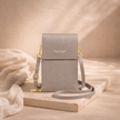 FJØRNA touchscreen crossbody phone bag for women, compact bag with transparent touchscreen window and adjustable strap.