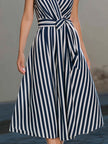 Navy vertical stripe sleeveless wrap midi dress by FJØRNA, stylish and elegant, shown on a model.