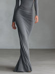 Grey knit ruched maxi dress by FJØRNA, featuring a fitted silhouette and elegant evening style, shown on a model.