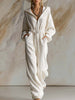 White corduroy hooded jumpsuit with zip front and long sleeves, women's pants by FJØRNA, styled with a casual look.
