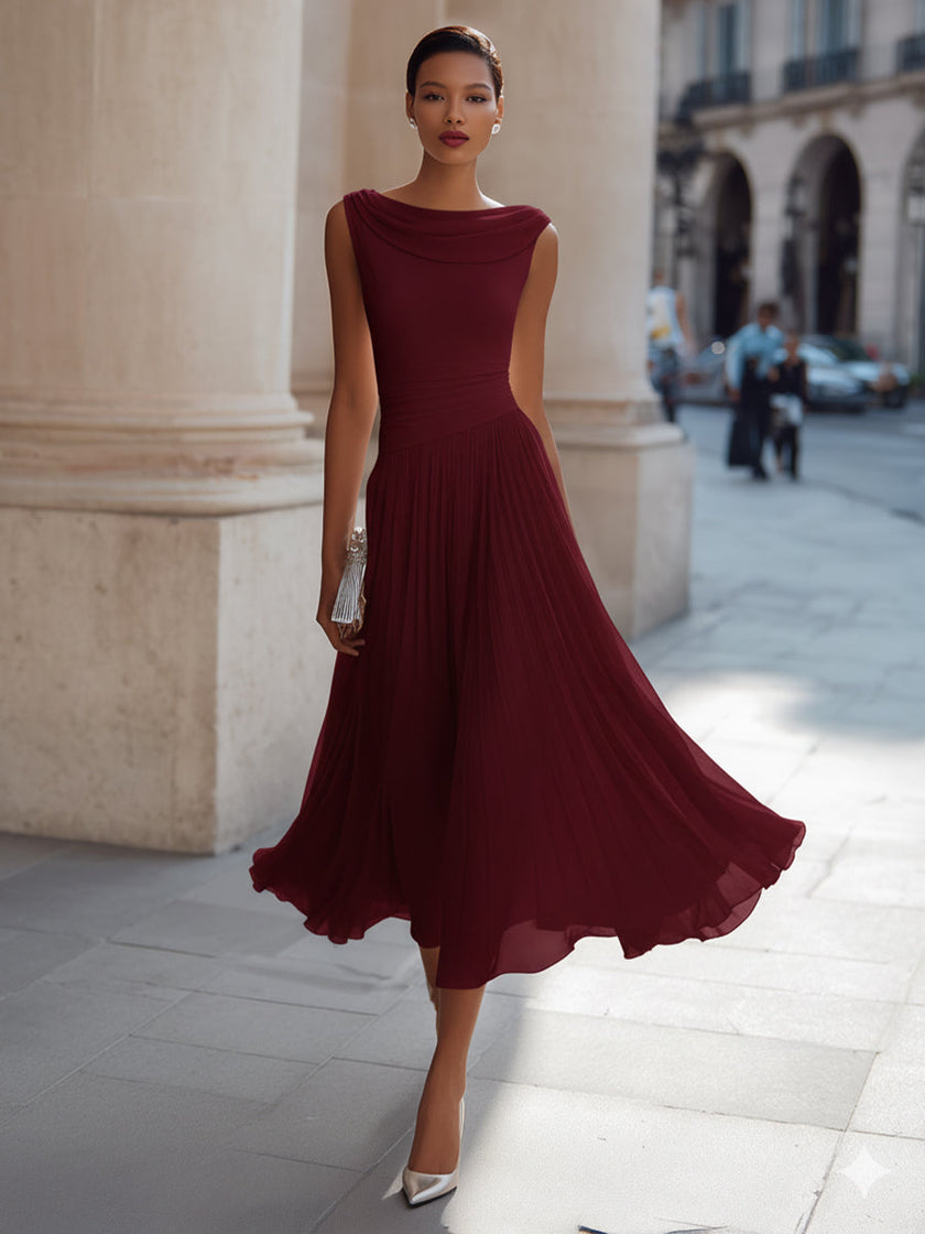 FJØRNA draped neck sleeveless pleated midi dress for wedding guests, featuring elegant flowy fabric and sophisticated style.