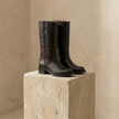 Tan knee-high block heel leather boots for women by FJØRNA, featuring winter-style shoes with sturdy heels and smooth leather finish.