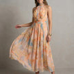 FJØRNA elegant women's maxi dress with halter neck and flowy fabric, shown from a side angle.