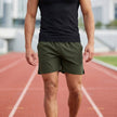 Men's army green athletic shorts by FJØRNA with elastic waist and side slits, casual and comfortable for active wear.