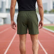 Men's athletic shorts by FJØRNA with elastic waistband and side slits, showing back detail and comfortable fit.