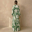 Back view of FJØRNA elegant women's maxi dress with V-neck and long sleeves, flowing fabric and fitted waist.
