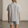 FJØRNA women's elegant two-piece striped co-ord set with button-front top and matching pants, shown from the back.