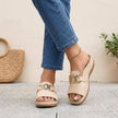 Beige FJØRNA orthopedic slide sandals with buckle detail and contrast stitching, featuring cushioned footbed and open toe design.