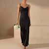 Black women's elegant maxi dress with cowl neck and cami straps by FJØRNA, showcasing a flowing, stylish evening wear silhouette.