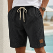 Black men's casual drawstring shorts with pockets and elegant accents, featuring a relaxed fit and stylish design by FJØRNA.