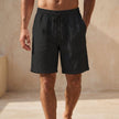 Black men's Quick-Dry Above-the-Knee Swim Shorts by FJØRNA, relaxed fit summer pants for beach and pool activities.
