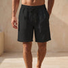 Black men's Quick-Dry Above-the-Knee Swim Shorts by FJØRNA, relaxed fit summer pants for beach and pool activities.