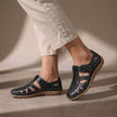 Black FJØRNA orthopedic closed-toe sandals with cutout details and a comfortable fit, designed for supportive footwear.