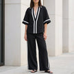 Black women's two-piece co-ord set by FJØRNA featuring a wide-leg pants and V-neck top, stylish and elegant.