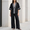Black women's two-piece co-ord set by FJØRNA featuring a wide-leg pants and V-neck top, stylish and elegant.