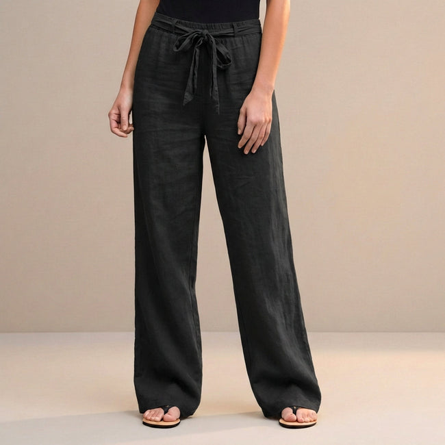 Black FJØRNA summer trousers for women, high-waist cotton pants, shown on a model highlighting the relaxed fit and stylish design.