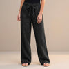 Black FJØRNA summer trousers for women, high-waist cotton pants, shown on a model highlighting the relaxed fit and stylish design.