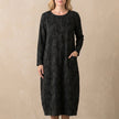 Black FJØRNA women's maxi dress with long sleeves and pockets, elegant and flowy for stylish everyday wear.