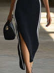 Black knit V-neck maxi dress for women by FJØRNA, featuring a flowing silhouette and long length, perfect for casual or elegant wear.